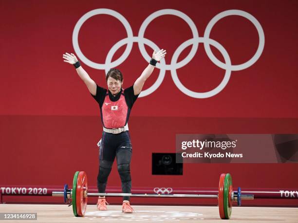 Japanese weightlifter Hiromi Miyake waves after failing to lift 99 kilograms in the jerk portion of the women's 49-kilogram event at the Tokyo...