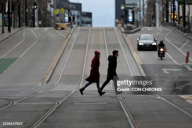 Pedestrians walk through the quiet streets of Melbourne on July 24 during the ninth day of the lockdown.