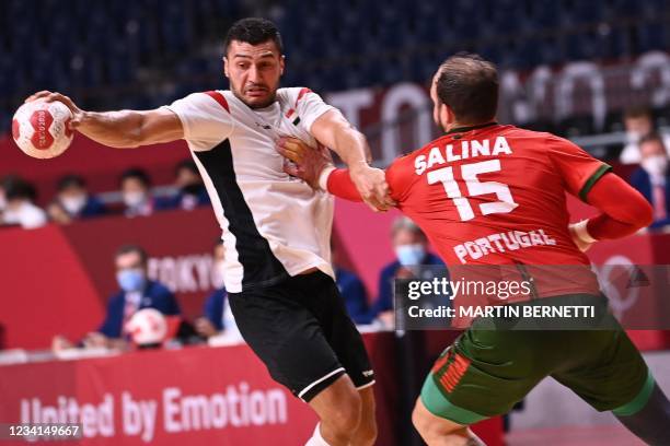Egypt's left back Yehia Elderaa is challenged during the men's preliminary round group B handball match between Portugal and Egypt during the Tokyo...