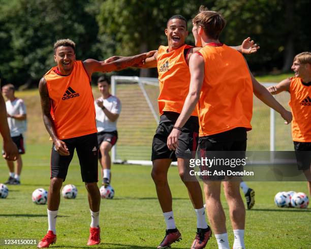 Mason Greenwood of Manchester United reacts with Jesse Lingard during a pre-season training session at Pennyhill Park on July 23, 2021 in Bagshot,...