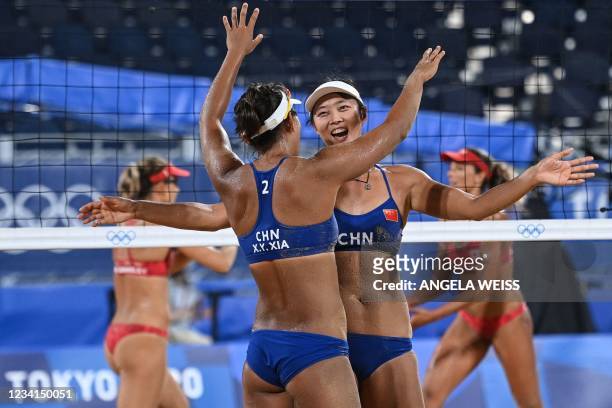 China's Xia Xinyi hugs partner Wang Fan in their women's preliminary beach volleyball pool C match between Canada and China during the Tokyo 2020...