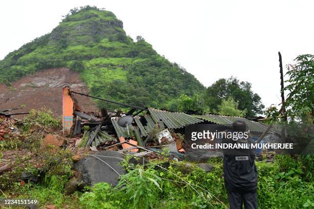 Man takes pictures of a landslide at Taliye, about 22 km from Mahad city on July 24 as the death toll from heavy monsoon rains climbed to 76, with...