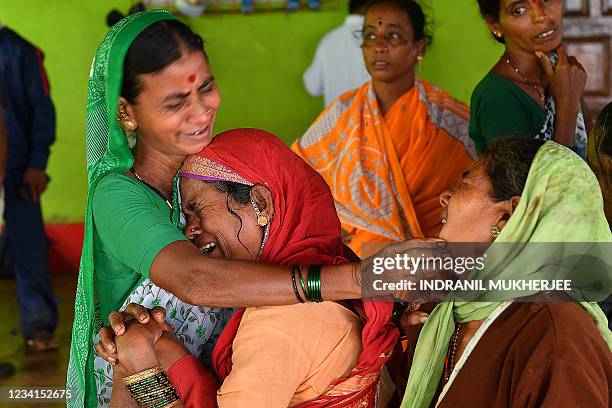 Villagers console a woman who lost a relative following a landslide at Taliye, about 22 km from Mahad city on July 24 as the death toll from heavy...