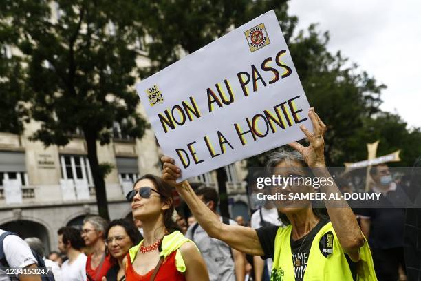 Protestor holds a placard reading "No to the pass of shame" during a demonstration against the compulsory vaccination for certain workers and the...