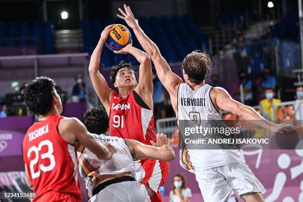 Japan's Tomoya Ochiai jumps to score past Belgium's Thibaut Vervoort during the men's first round 3x3 basketball match between Belgium and Japan at...