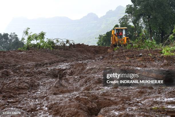 Workers use an excavator at the site of a landslide at Taliye, about 22 km from Mahad city on July 24 as the death toll from heavy monsoon rains...