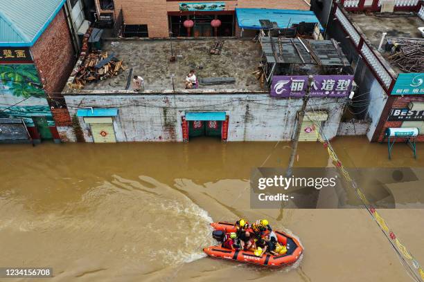 This aerial photo taken on July 23, 2021 shows rescue workers evacuating residents following heavy rains in Xinxiang, in China's central Henan...