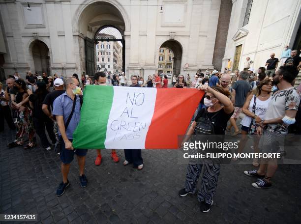 Protesters hold an Italian flag as they take part in a demonstration in Piazza del Popolo in Rome on July 24 against the introduction of a mandatory...
