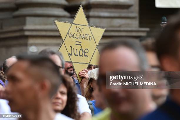 Protester holds a Yellow Star reading "Not Vaccinated = Jew" as protesters take part in a demonstration in Milan on July 24 against the introduction...