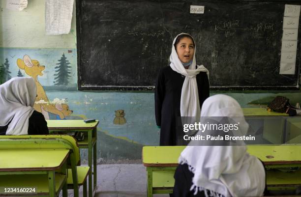 An Afghan student stands in front of her classroom talking about Eid during English class at the Zarghoona high school on July 24 2021 in Kabul,...