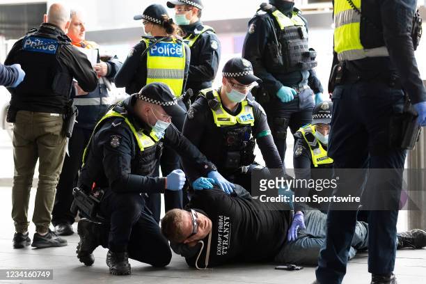 Demonstrator is seen on the floor as he resists arrest during the Freedom protest on July 24, 2021 in Melbourne, Australia. Freedom protests are...