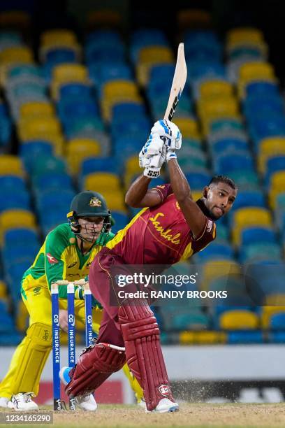 Nicholas Pooran of West Indies hits 6 and Alex Carey of Australia watch during the 2nd ODI between West Indies and Australia at Kensington Oval,...