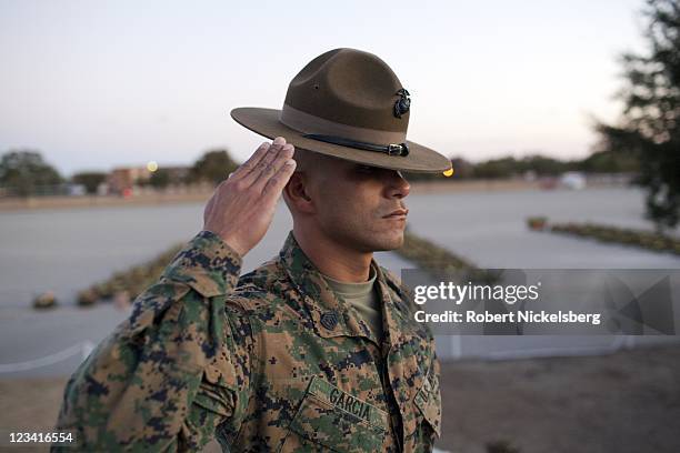 Marine Corps Drill Instructor salutes during a dawn ceremony for new Marines after a 9-mile hike ending the 54-hour Crucible exercise January 8, 2011...