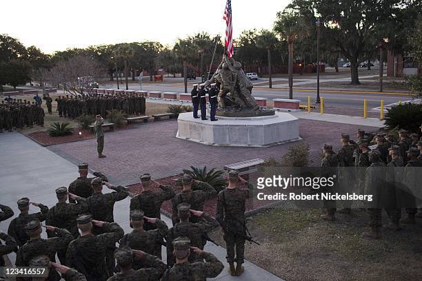 Marines raise the American flag during a dawn ceremony for new Marines after ending the 54-hour Crucible exercise January 8, 2011 at the Marine Corps...