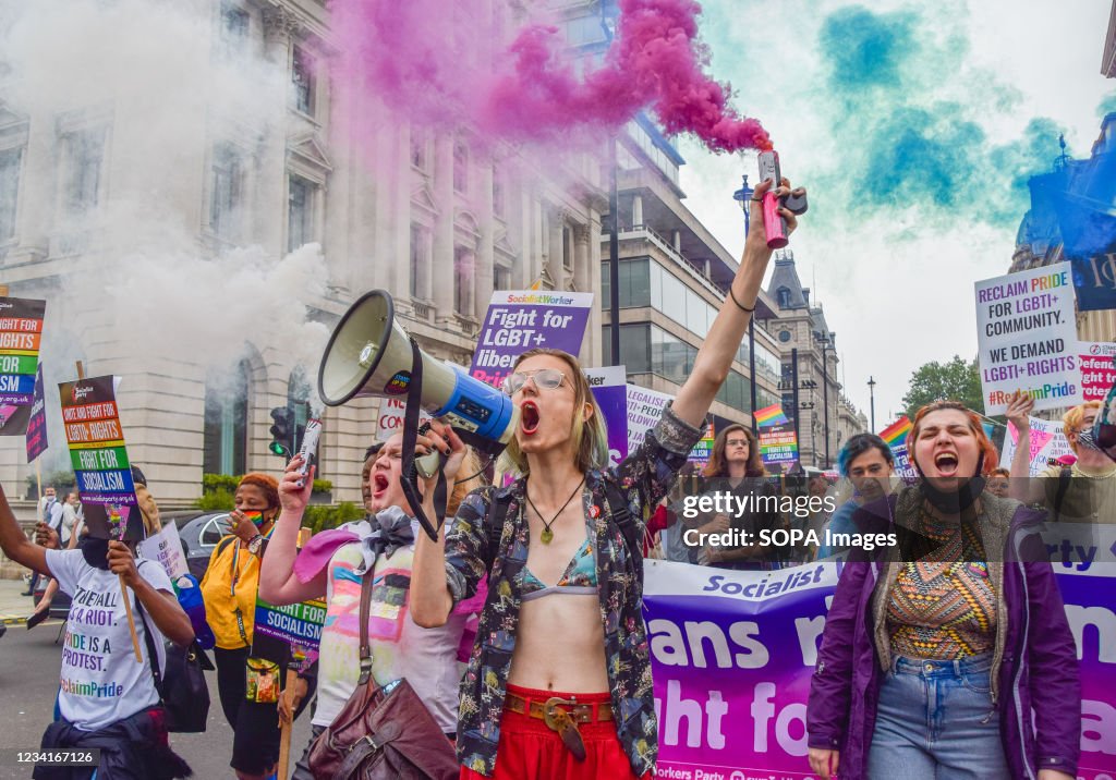 A demonstrator shouts through a megaphone and holds a smoke...