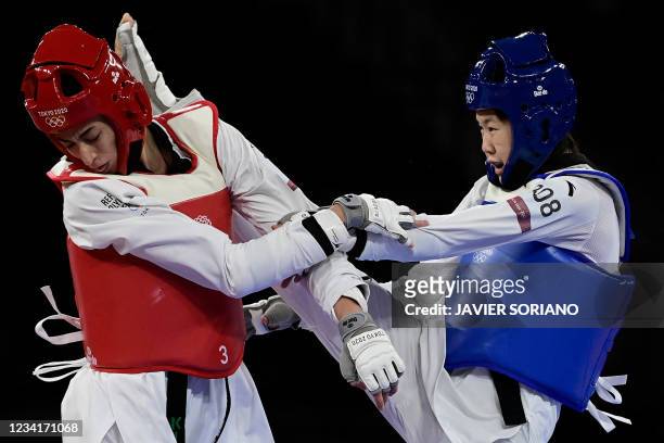 China's Zhou Lijun and Refugee Olympic Team's Kimia Alizadeh Zenoorin compete in the taekwondo women's -57kg quarter-final bout during the Tokyo 2020...