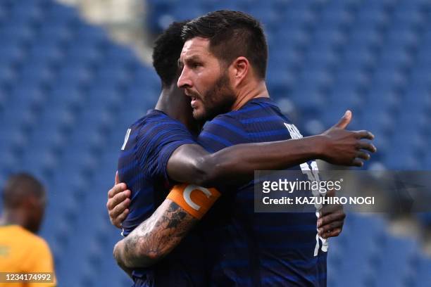 France's forward Andre-Pierre Gignac celebrates with a teammate after scoring the equaliser during the Tokyo 2020 Olympic Games men's group A first...