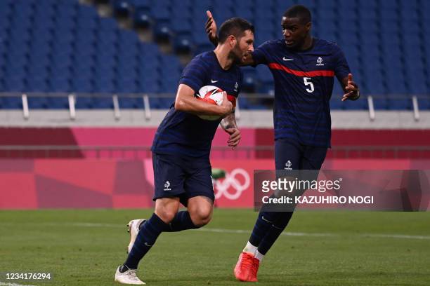 France's forward Andre-Pierre Gignac is congratulated by France's defender Niels Nkounkou after scoring the third goal during the Tokyo 2020 Olympic...
