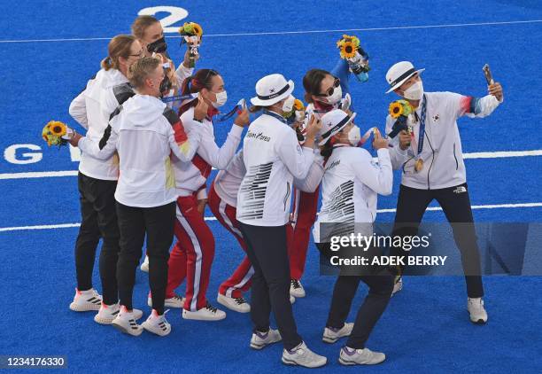 South Korea's An San takes a photograph with her gold medallist teammates Jang Min-hee and Kang Chae-young, silver medallists Russia's Ksenia Perova,...