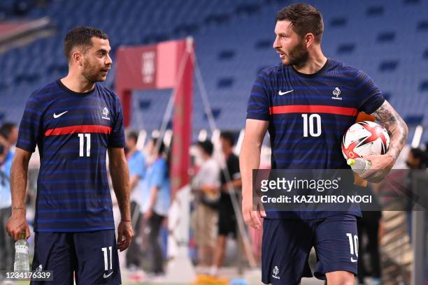 France's forward Andre-Pierre Gignac speaks France's midfielder Teji Savanier after their win the Tokyo 2020 Olympic Games men's group A first round...