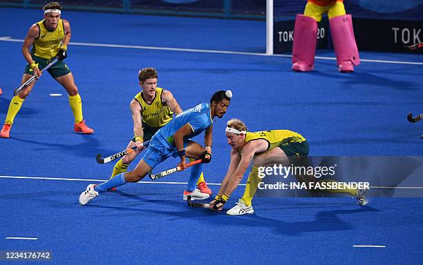Australia's Matthew Dawson and Aran Zalewski vie for the ball with India's Dilpreet Singh during their men's pool A match of the Tokyo 2020 Olympic...