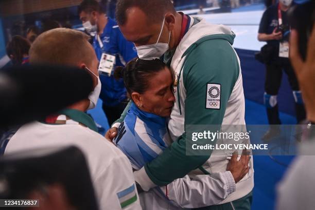 Uzbekistan's Oksana Chusovitina reacts with members of her team after competing in the artistic gymnastics vault event of the women's qualification...