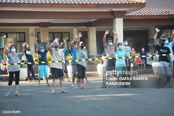Medical workers lead a group of recovering Covid-19 patients in a group exercise outside a hospital in Semarang on July 25, 2021.