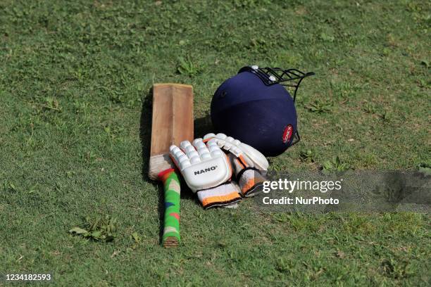 Cricket bat, Gloves and Helmet is kept in the ground by a Batsman during drinks break during a Cricket Match at Nadihal Baramulla, Jammu and Kashmir,...