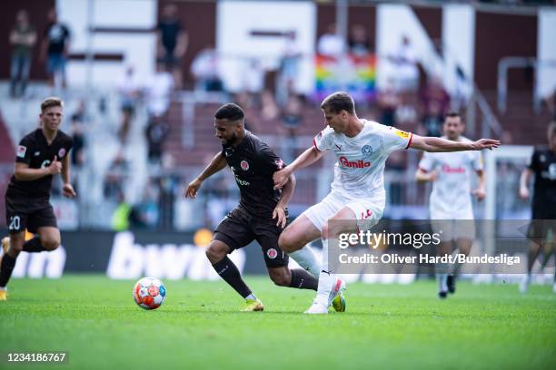 Daniel Kofi Kyereh of FC St. Pauli competes for the ball with Patrick Erras of Holstein Kiel during the Second Bundesliga match between FC St. Pauli...