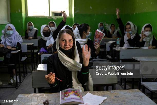 Zinat Karimi raises her hand during 10th-grade class at the Zarghoona high school on July 25 2021 in Kabul, Afghanistan. The Zarghoona girls high...