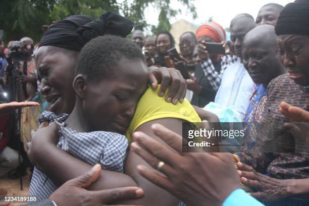 Mother hugs her daughter on July 25, 2021 after she was released together with other 27 students of the Bethel Baptist High School. Gunmen who seized...