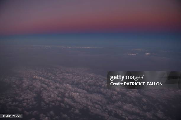 Haze of wildfire smoke and clouds is seen at sunset in an aerial image taken during a flight from Seattle to Los Angeles as western wildfires...