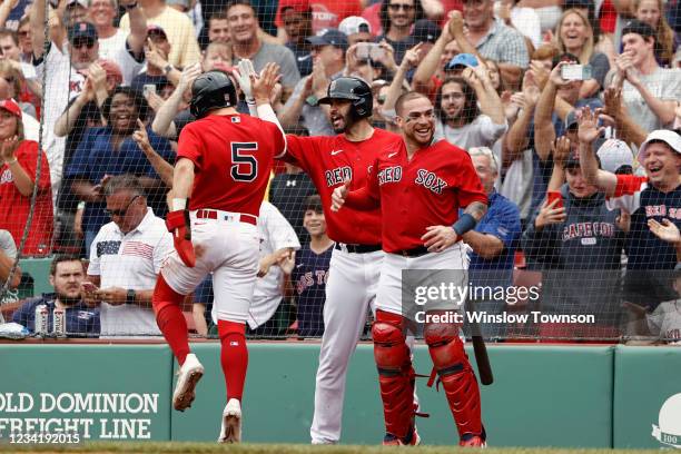 Enrique Hernandez of the Boston Red Sox celebrates with J.D. Martinez, center, and catcher Christian Vazquez after scoring the go ahead run during...