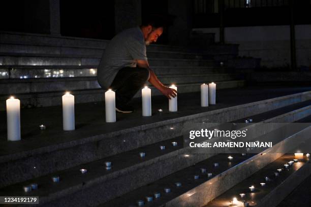 Man lights up a candle in Pristina on July 25, 2021 to pay tribute for the Kosovo Albanian victims who died in a bus crash in Croatia. - Ten people...