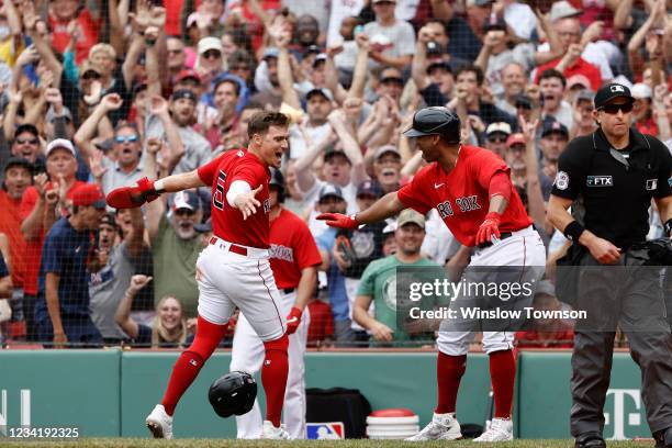 Enrique Hernandez of the Boston Red Sox is congratulated by Rafael Devers after scoring the go ahead run during the eighth inning of their 5-4 win...