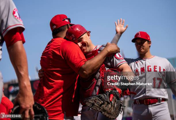 Max Stassi of the Los Angeles Angels is embraced by catching coach Jose Molina after the game against the Minnesota Twins at Target Field on July 25,...
