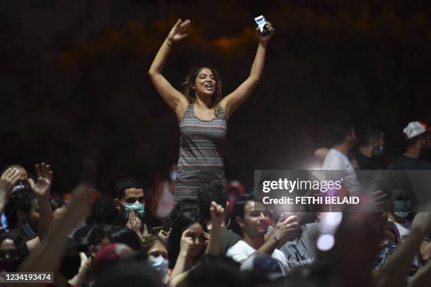 People celebrate in the streets of Tunis after Tunisian President Kais Saied announced the suspension of parliament and the dismissal of the prime...