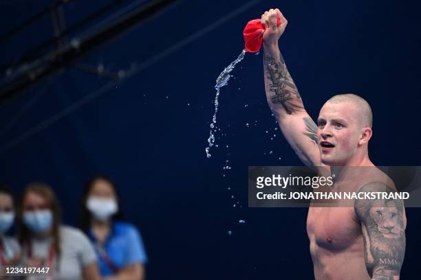 Britain's Adam Peaty celebrates winning to take gold in the final of the men's 100m breaststroke swimming event during the Tokyo 2020 Olympic Games...