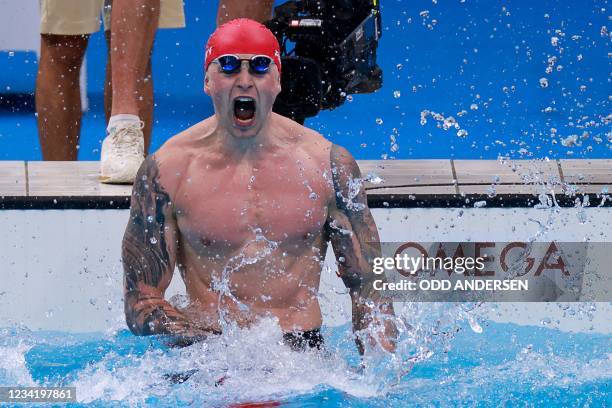 Britain's Adam Peaty celebrates winning to take gold in the final of the men's 100m breaststroke swimming event during the Tokyo 2020 Olympic Games...