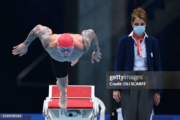 Britain's Adam Peaty dives to start in the final of the men's 100m breaststroke swimming event during the Tokyo 2020 Olympic Games at the Tokyo...