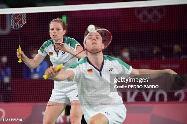 Germany's Mark Lamsfuss hits a shot next to Germany's Isabel Herttrich in their mixed doubles badminton group stage match against Hong Kong's Tang...