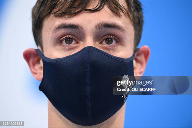 Tears well in the eyes of gold medallists Britain's Thomas Daley and Britain's Matty Lee as they wait to receive their medals after wining the men's...