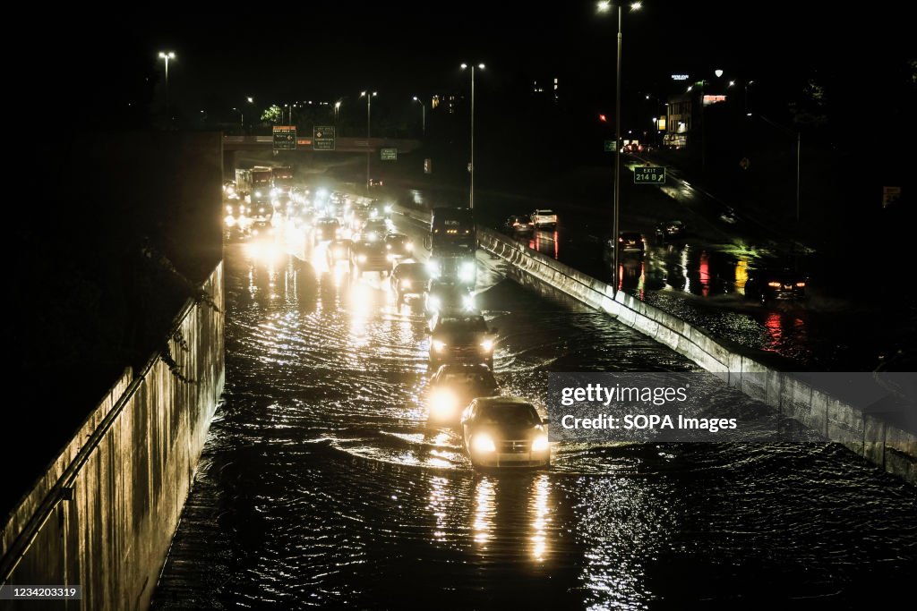 Vehicles cautiously drive through floodwaters on I-94...