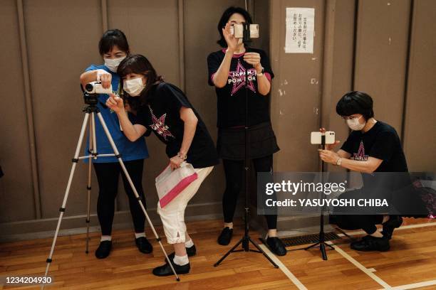 Members of the Japanese senior cheerleading squad "Japan Pom Pom" set up their smartphones and video cameras to record their practice session in...