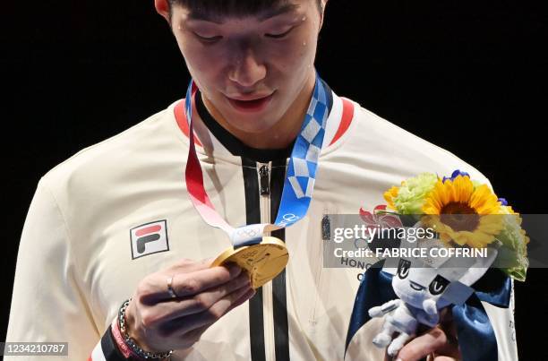 Gold medallist Hong Kong's Cheung Ka Long looks the medal as he celebrates on podium during the medal ceremony for the mens individual foil during...