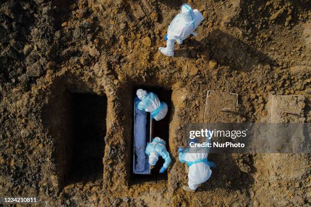 Aerial view of health workers wearing personal protective equipment during the burial of Covid-19 victims in Klang, Malaysia on July 26, 2021....