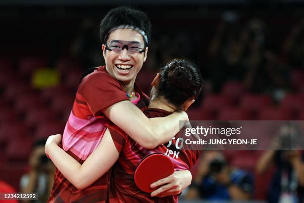 Japan's Jun Mizutani and Mima Ito celebrate after beating China's Xu Xin and Liu Shiwen in their mixed doubles table tennis final match at the Tokyo...