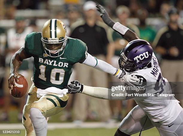 Baylor quarterback Robert Griffin III eludes Texas Christian University defensive end Stansly Maponga during the third quarter at Floyd Casey Stadium...