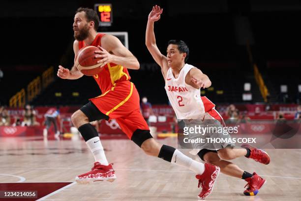 Spain's Sergio Rodriguez runs with the ball past Japan's Yuki Togashi in the men's preliminary round group C basketball match between Japan and Spain...