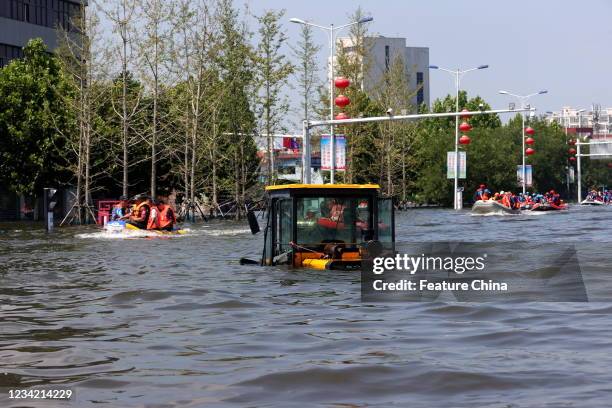 Rescuers transfer citizens out of the flooded zone in a massive evacuation effort in Weihui city in central China&#039;s Henan province Monday, July...